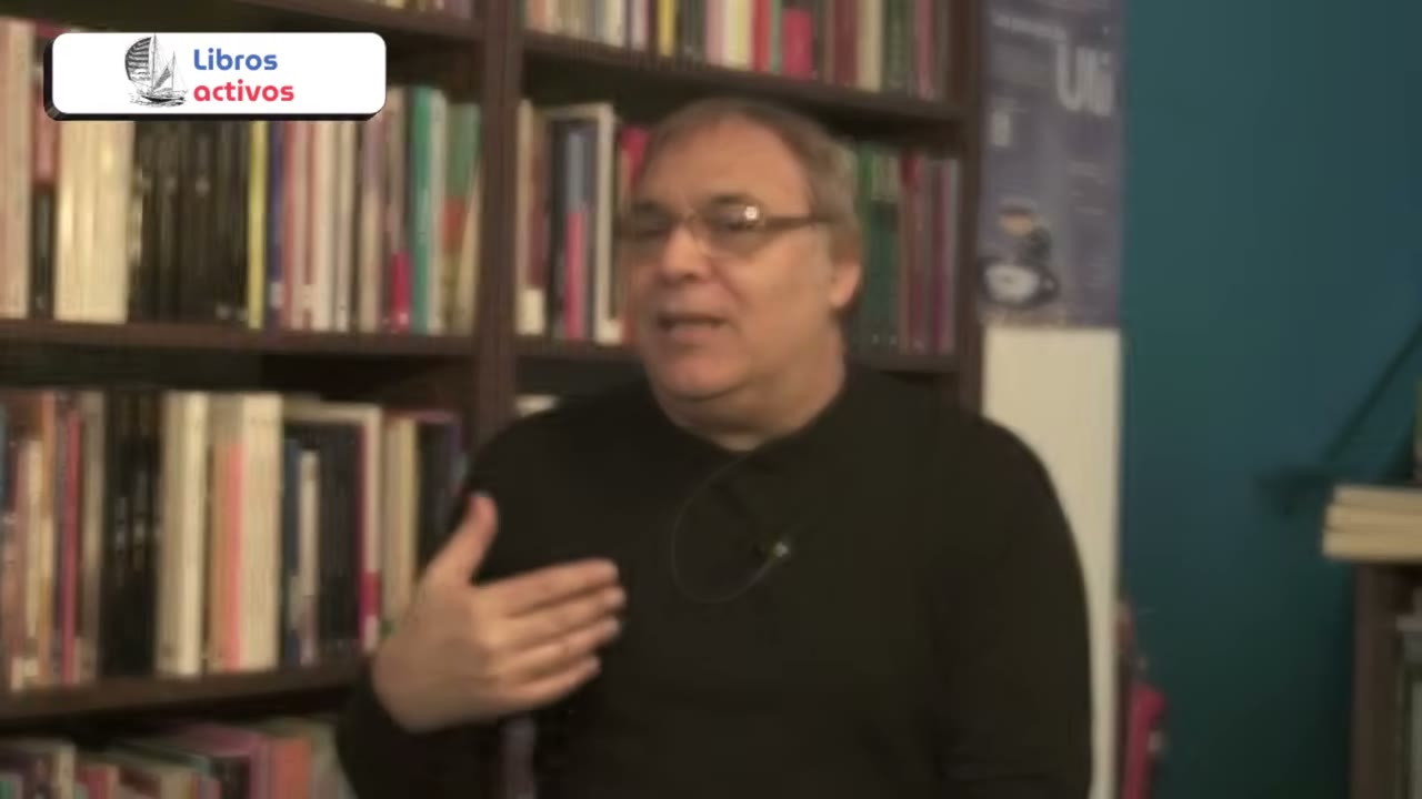 Gabriel Rolón hablando frente a una biblioteca.
